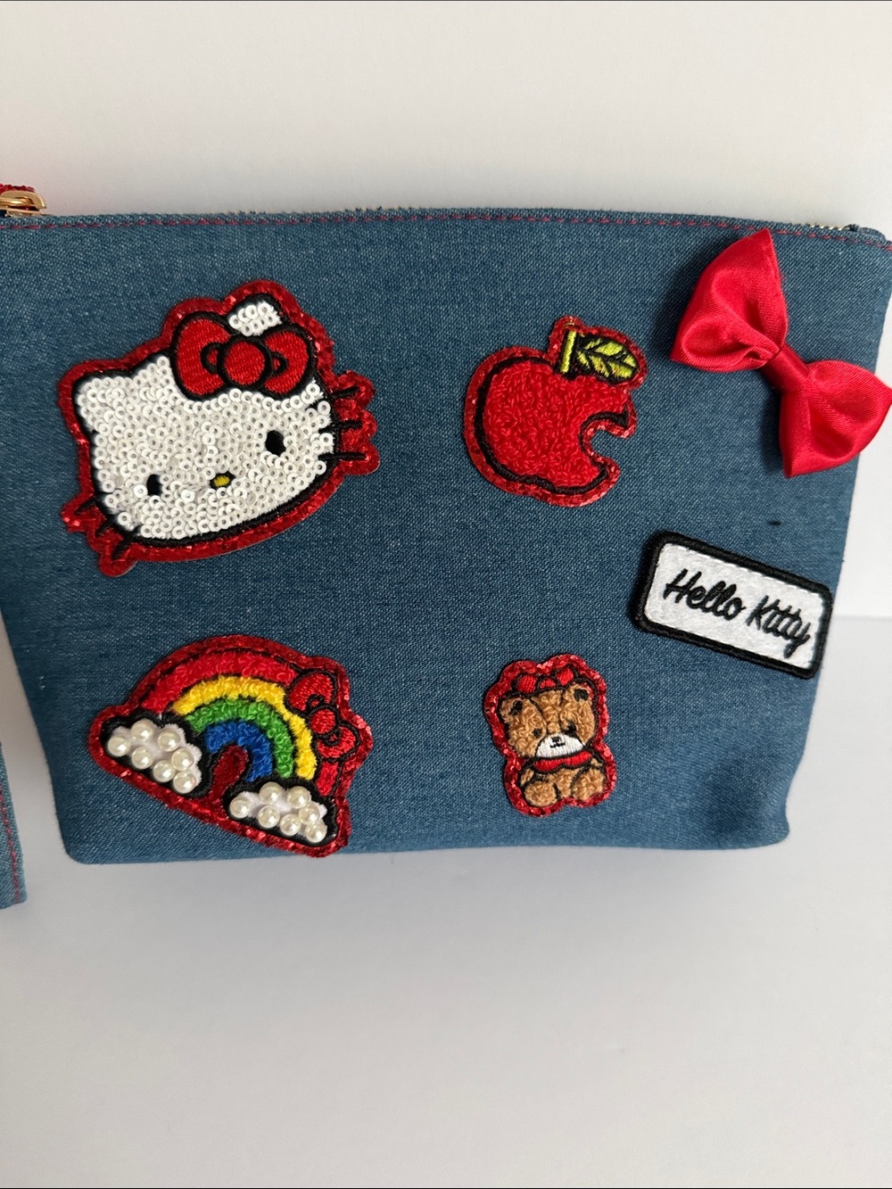 Blue denim pouch featuring embroidered Hello Kitty patches and a red satin bow - Picture 2 of 6